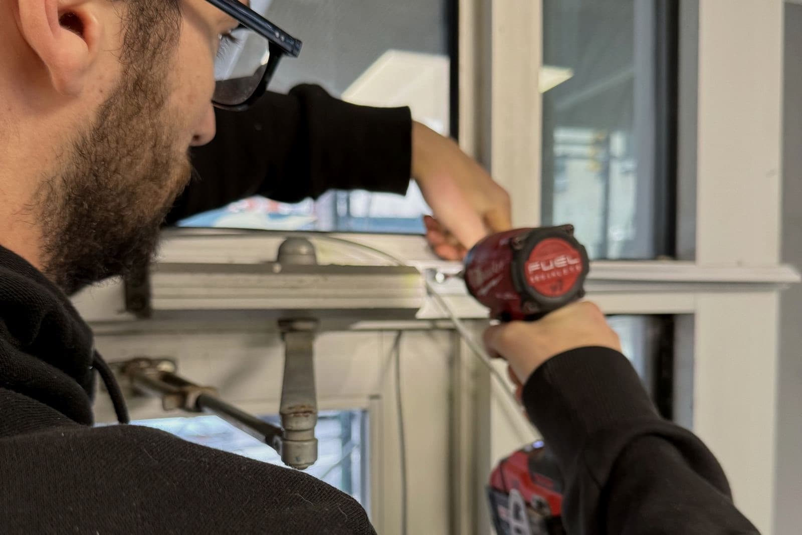 Technician servicing a window lock on site